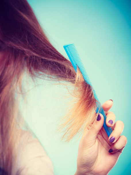 Long haired woman combing her hair. - Fotó, kép