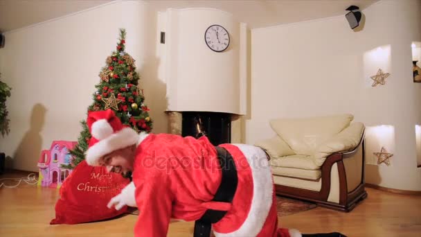 Καλό νέο έτος πνεύμα: Άγιος Βασίλης, το χριστουγεννιάτικο δέντρο, τσάντα δώρο, τζάκι - ντυμένος πανηγυρικά δύο γενιάς οικογένεια γιορτάζει χειμερινές διακοπές, να χορεύει μπροστά από την κάμερα και να παίζουν ανόητος.  - Πλάνα, βίντεο