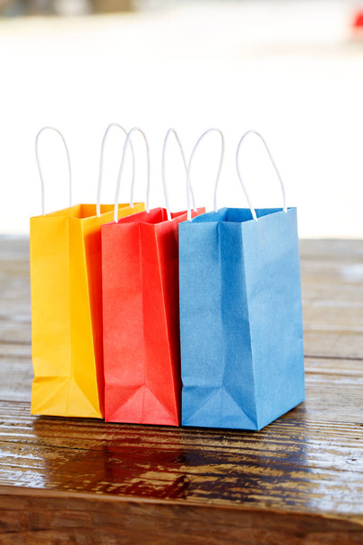 Colorful paper bags on light blurred background - Foto, imagen