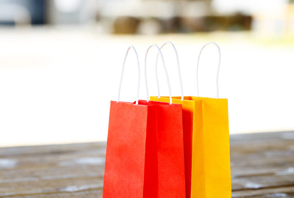 Colorful paper bags on light blurred background - Foto, afbeelding