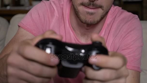 Closeup of competitive focused guy working out winning video game session controlling remote buttons in slowmo - Video