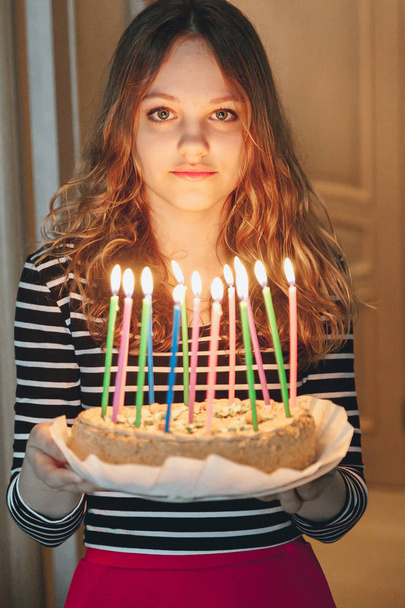 Young beautiful girl holding cake with burning candles - Фото, зображення