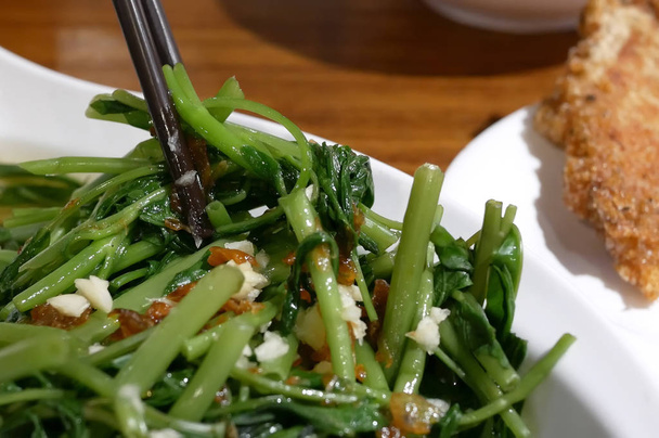 Movimiento de personas comiendo verduras dentro de restaurante chino
 - Foto, imagen