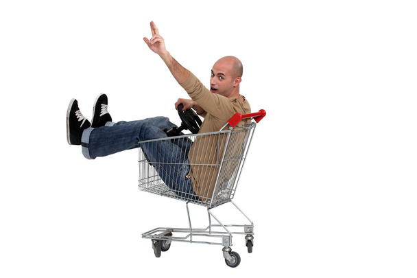 Man in a shopping trolley - Фото, изображение