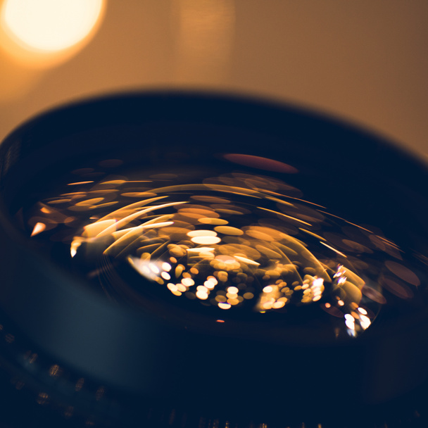 close-up shot of holiday lights reflecting in glass of camera lens - Fotó, kép