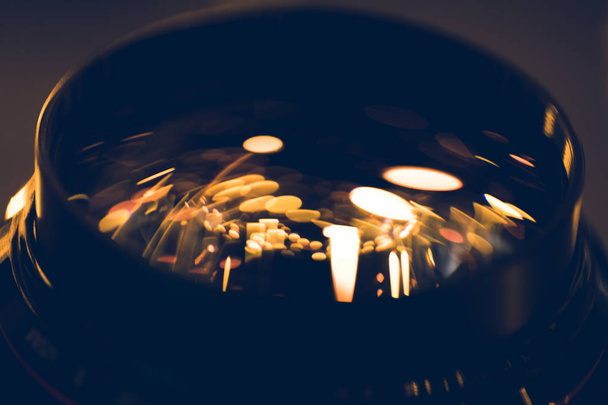 primer plano de las luces doradas reflejándose en el vidrio de la lente
 - Foto, Imagen