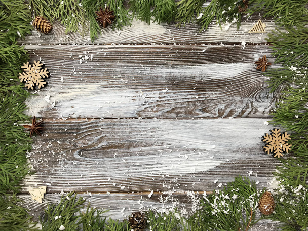 Fondo de madera de Navidad con ramas de abeto, copos de nieve de madera y conos de pino. Marco de Año Nuevo floral. Frontera con espacio de copia
. - Foto, imagen