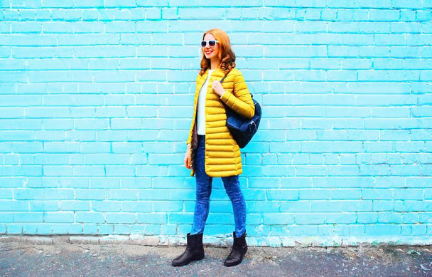 Fashion pretty woman with backpack on a colorful blue brick back - Photo, Image