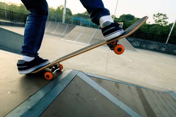 skateboarder legs skateboarding on skatepark ramp - Foto, imagen