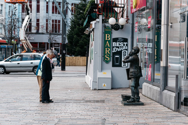 Les gens devant la statue de la rue St Patrick à Cork
 - Photo, image