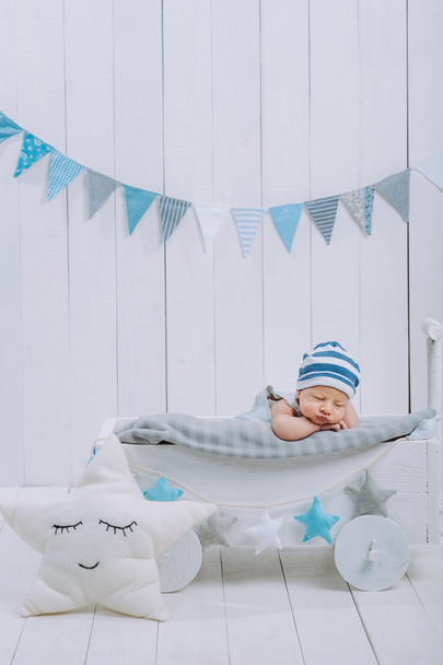 aranyos újszülött baba alszik fa kiságy csillag párna közelében a kalapban  - Fotó, kép