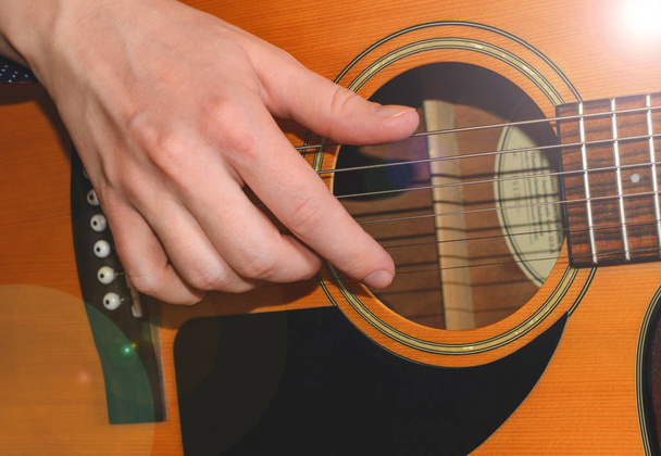 Musician playing acoustic guitar, close up - Foto, imagen
