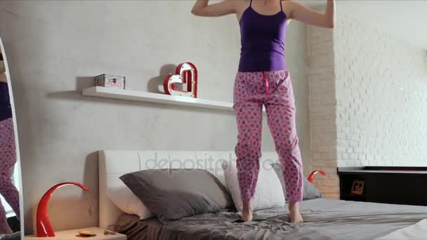Mutlu genç kadın kız yatakta atlama için iyi haber - Video, Çekim