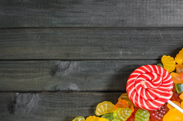 jelly and marmalade candies on a wooden background with free space for text. - Φωτογραφία, εικόνα
