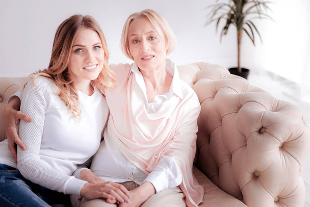 Delighted positive mother and daughter resting on the sofa - Fotoğraf, Görsel