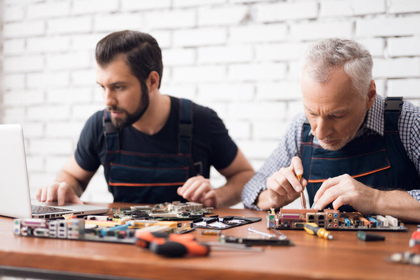 Adult and young men repair parts from the computer together. - Fotografie, Obrázek