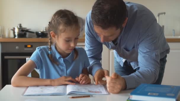 Father helping daughter with homework at home. - Záběry, video