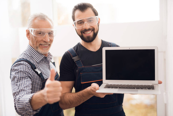 Elderly and young men posing together on the camera with a laptop. - Foto, Imagen