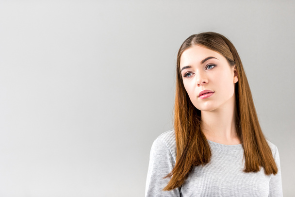 portrait of pensive young woman looking away isolated on grey - Фото, зображення