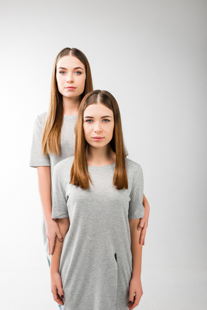 portrait of young pensive woman hugging twin sister - Photo, Image