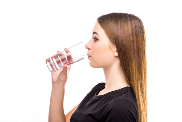 vista laterale della giovane donna che beve acqua da vetro isolato su bianco
 - Foto, immagini