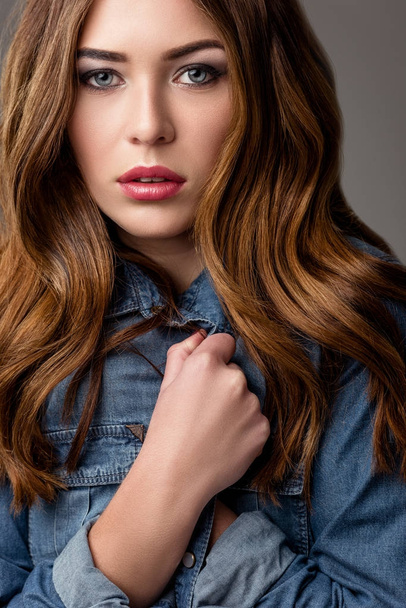 portrait of beautiful pensive woman in jeans jacket looking at camera - Photo, Image