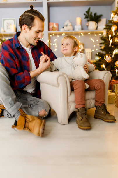 Festive image of happy son and dad on armchair - Foto, Imagen