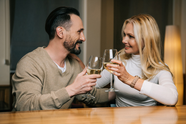 happy mature couple drinking wine and smiling each other in hotel restaurant   - Foto, afbeelding
