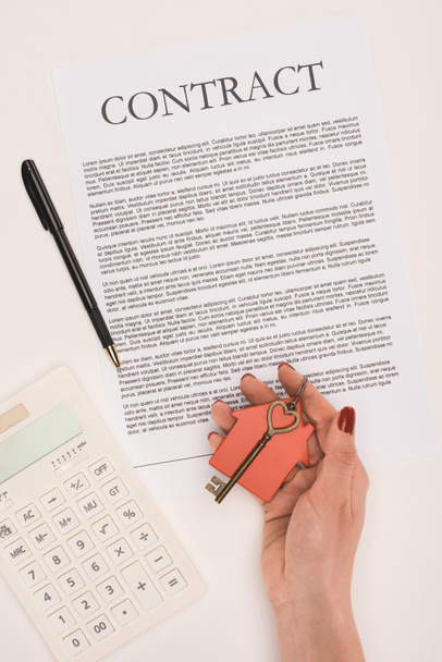 pohled shora oříznutého ruka drží klíče od domu nad smlouvu izolované na bílém - Fotografie, Obrázek