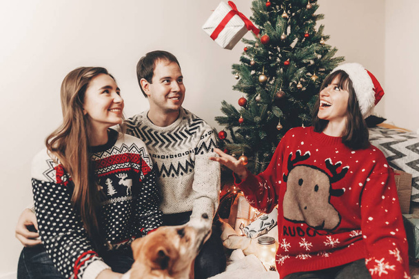 famiglia felice divertirsi con i regali e giocare con il cane all'albero di Natale con la luce
 - Foto, immagini