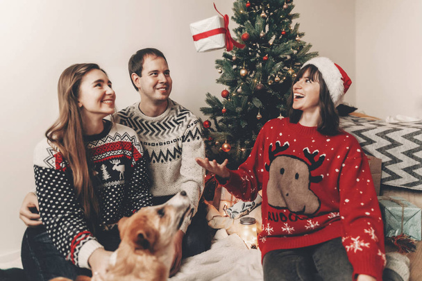 famiglia felice divertirsi con i regali e giocare con il cane all'albero di Natale con la luce
 - Foto, immagini