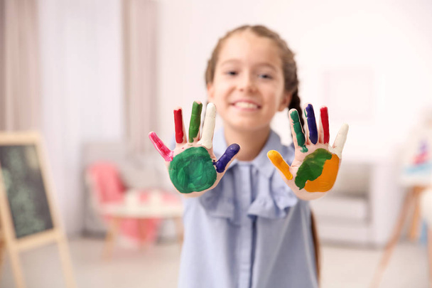 Little girl with painted hands indoors - Fotó, kép