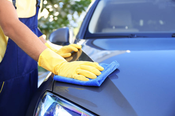 Man cleaning car with rag outdoors - Фото, зображення