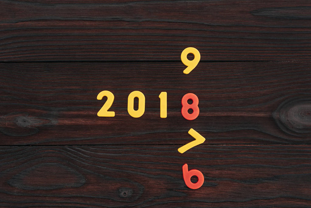 top view of colorful 2018 numbers on dark wooden surface - Foto, imagen