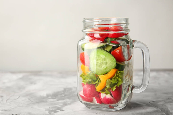 Delicious vegetable salad in mason jar on table - Fotoğraf, Görsel