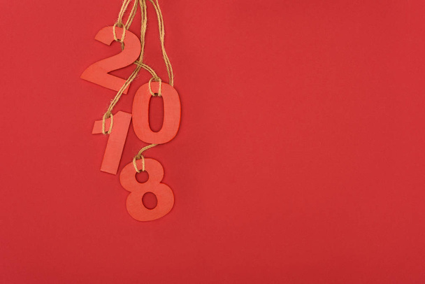 close up view of 2018 year sign hanging on strings isolated on red - Foto, imagen