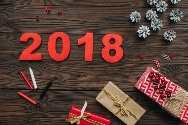 plat laïc avec cadeaux de Noël, cônes de pin et 2018 année signe sur table en bois foncé
 - Photo, image