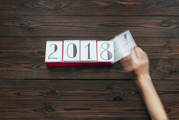 plan recadré de papier calendrier déchirant femme de 2018 année avec la surface en bois sombre comme fond
 - Photo, image