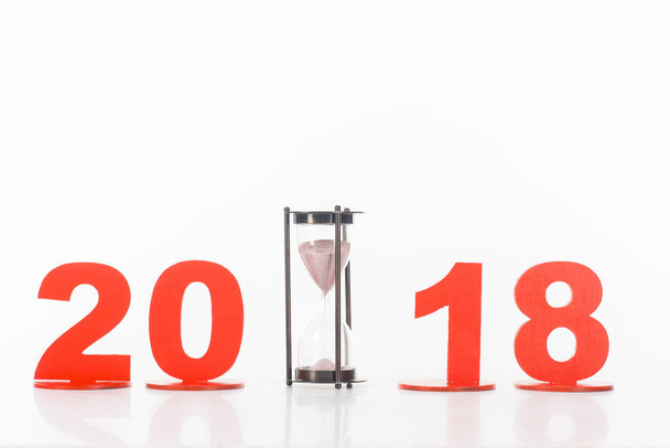 close up view of sand clock and 2018 year sign isolated on white - Fotó, kép