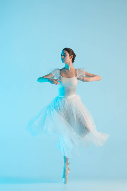 Young and incredibly beautiful ballerina is dancing in a blue studio - Foto, Bild