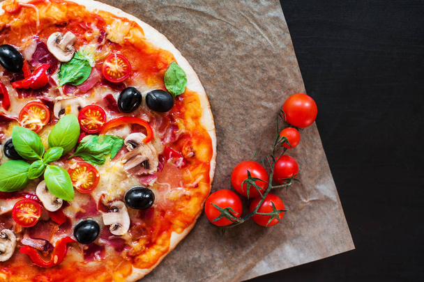 Hot pizza slice with Pepperoni, cheese, mozzarella and tomato  on a rustic background  close up. - Foto, afbeelding