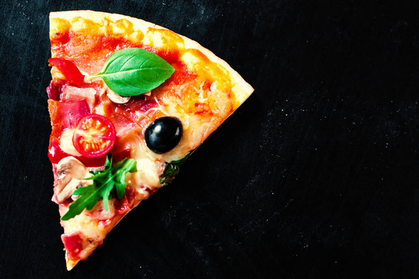 Ham, tomato and cheese  pizza on dark  background. Hot pizza with Pepperoni Sausage served at a pizzeria or restaurant - Foto, afbeelding