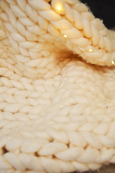 Grande couverture en laine mérinos tricotée à la main avec rose, fil super épais, concept tendance. Gros plan de couverture tricotée, fond en laine mérinos
 - Photo, image