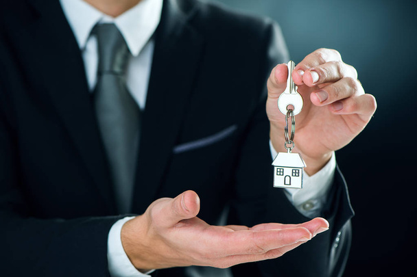 key chain with key in hand of a real estate agent - Fotoğraf, Görsel