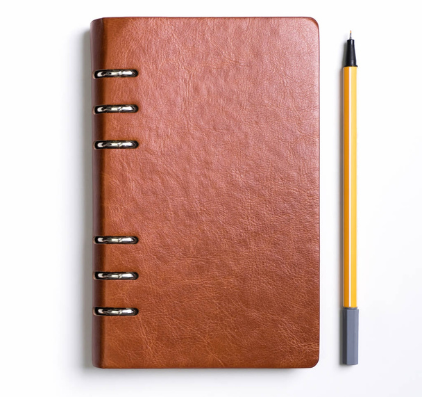 Notizbuch mit gelbem Stift auf weißem Hintergrund - Foto, Bild
