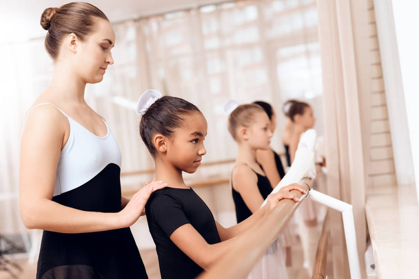 The trainer of the ballet school helps young ballerinas perform different choreographic exercises. - 写真・画像