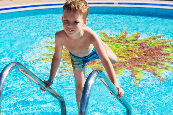 Enfant heureux jouant dans l'eau bleue de la piscine. Petit garçon Lea
 - Photo, image