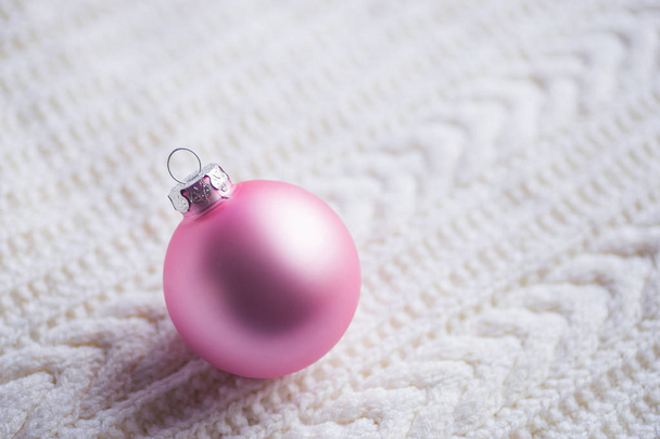 Pastel rosa bola de Navidad en tela de punto blanco
 - Foto, imagen