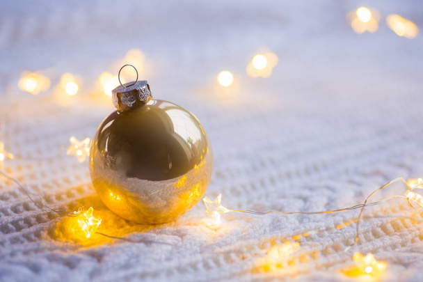 Χρυσή μπάλα Χριστούγεννα με φώτα γιρλάντα ζεστό λευκό πλεκτό  - Φωτογραφία, εικόνα