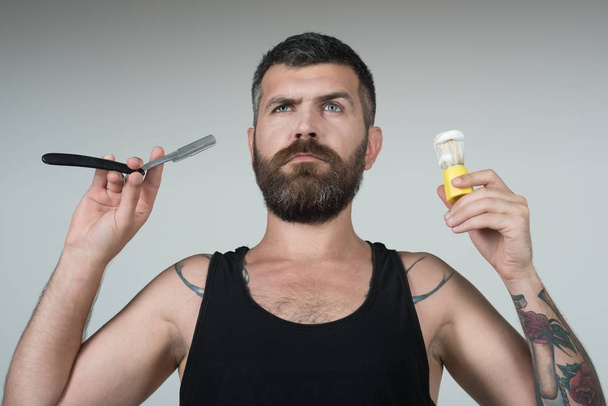 Man cut beard and mustache with razor and shaving brush. - Фото, изображение